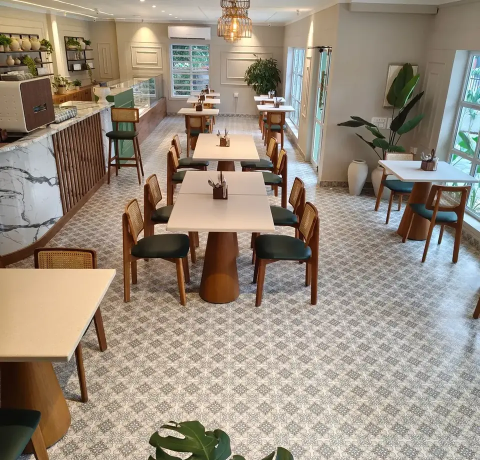 Interior luminoso de una cafetería contemporánea con mesas junto a la ventana