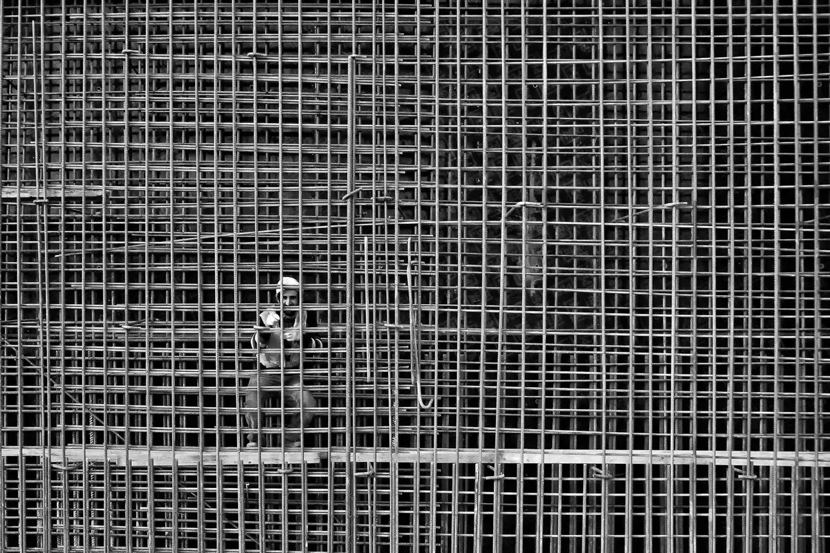 Trabajador con acero de refuerzo en obra, fotografía ilustrativa
