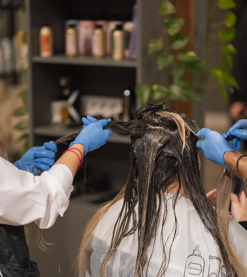 Coloristas trabajando en el cabello de una clienta
