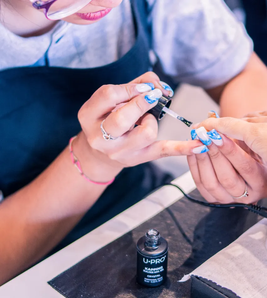 Profesional aplicando esmalte durante un manicure