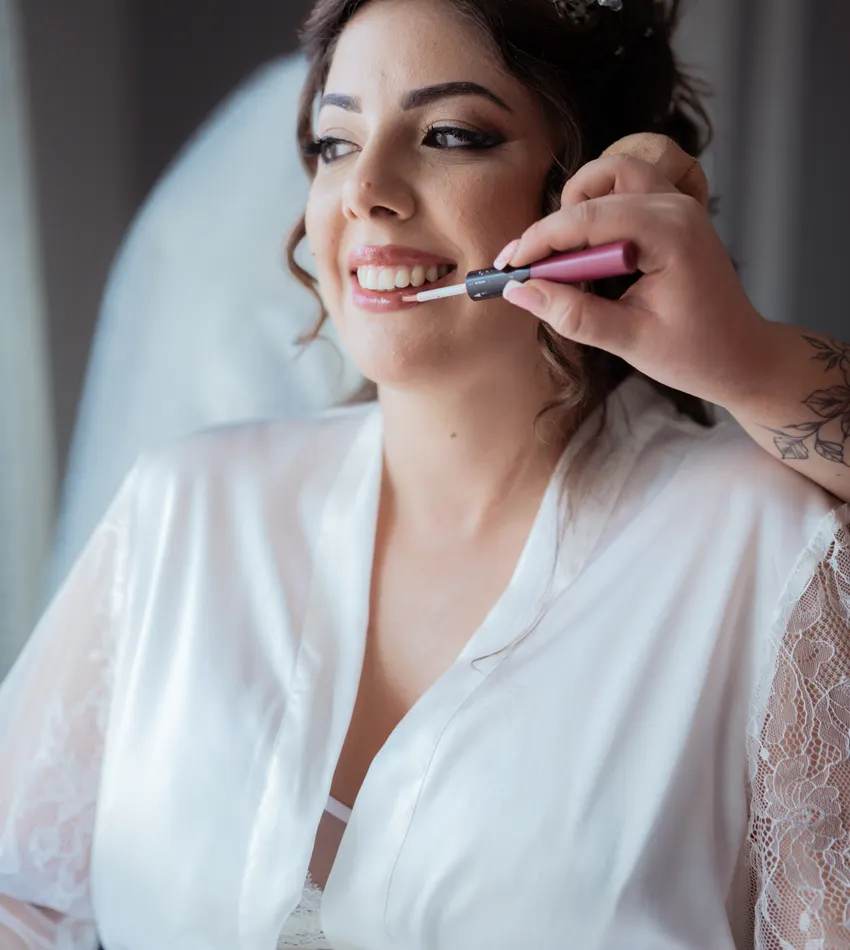 Novia sonriendo mientras recibe maquillaje
