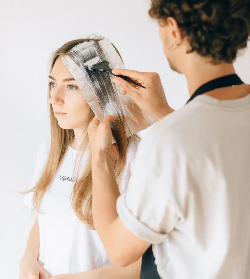 Aplicación de color en el cabello de una clienta